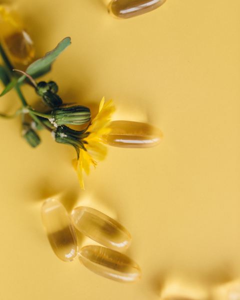Softgel capsules and yellow flowers